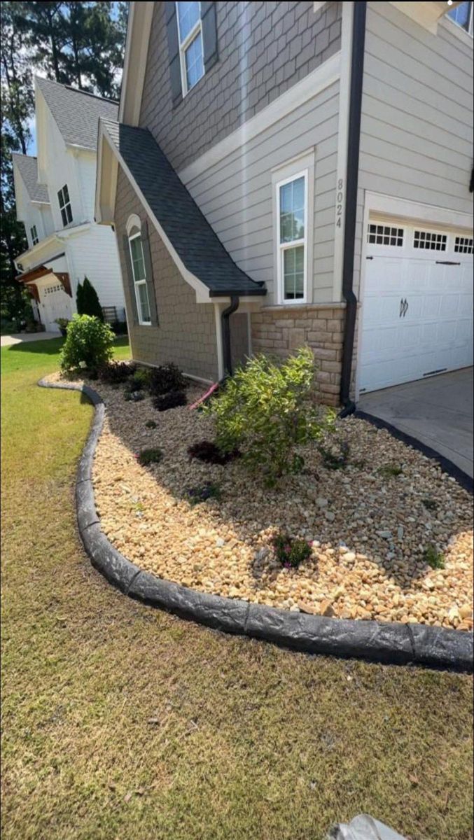 Curved concrete curbing winding around a residential landscape bed in eastern NC