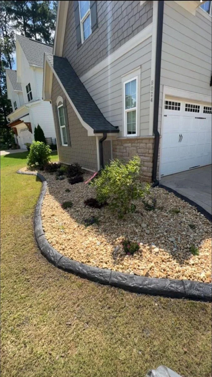 Curved concrete curbing winding around a residential landscape bed