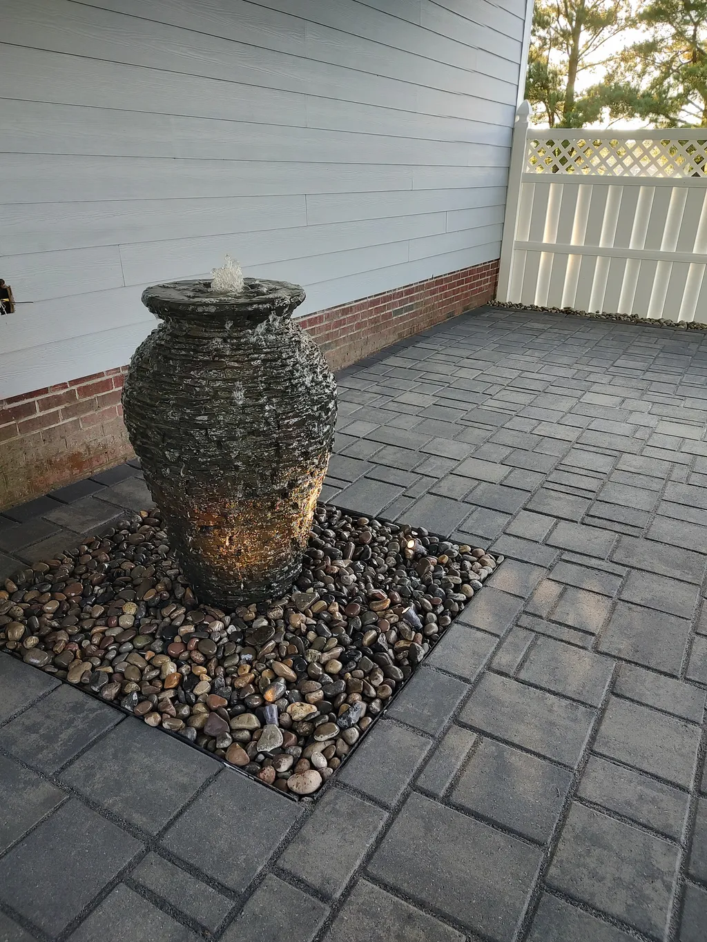 A finished stone water feature and fountain in a residential backyard