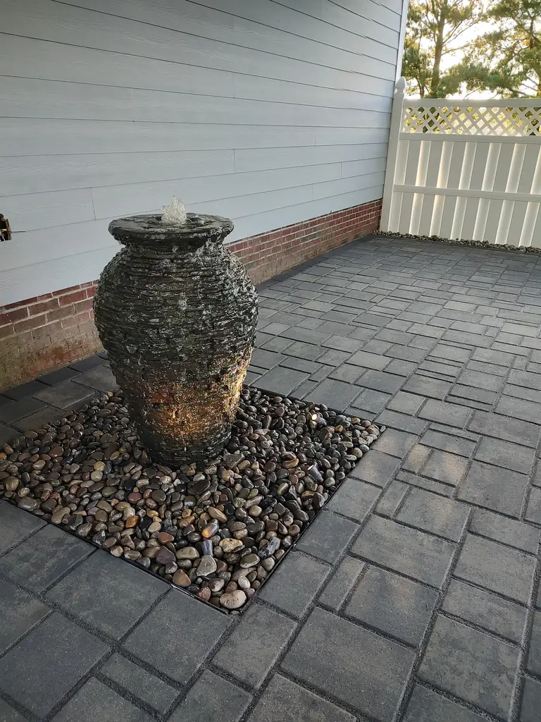 A finished stone water feature and fountain in a residential backyard